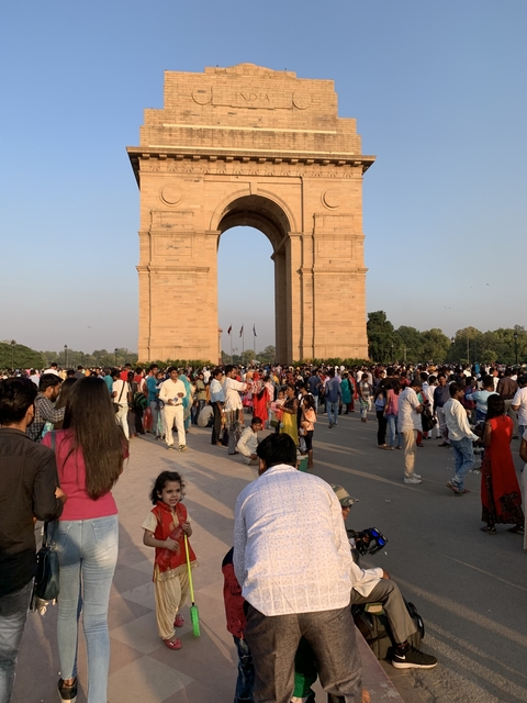       Large crowd gathering at an iconic stone arch monument.
  