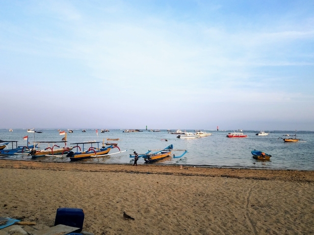 Boats floating near a sandy beach