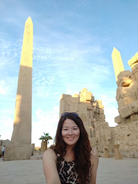       Person standing with ancient ruins in the background
  
