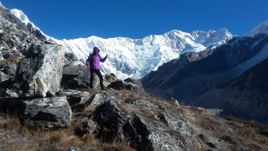 Person hiking in the mountains with snowy peaks.