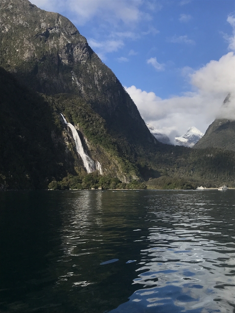 Waterfall cascading down a lush green mountain.