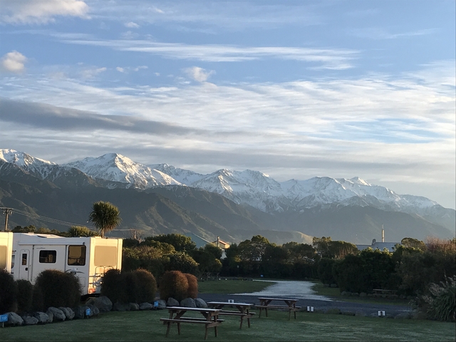 Scenic view of snow-capped mountains and lush greenery.