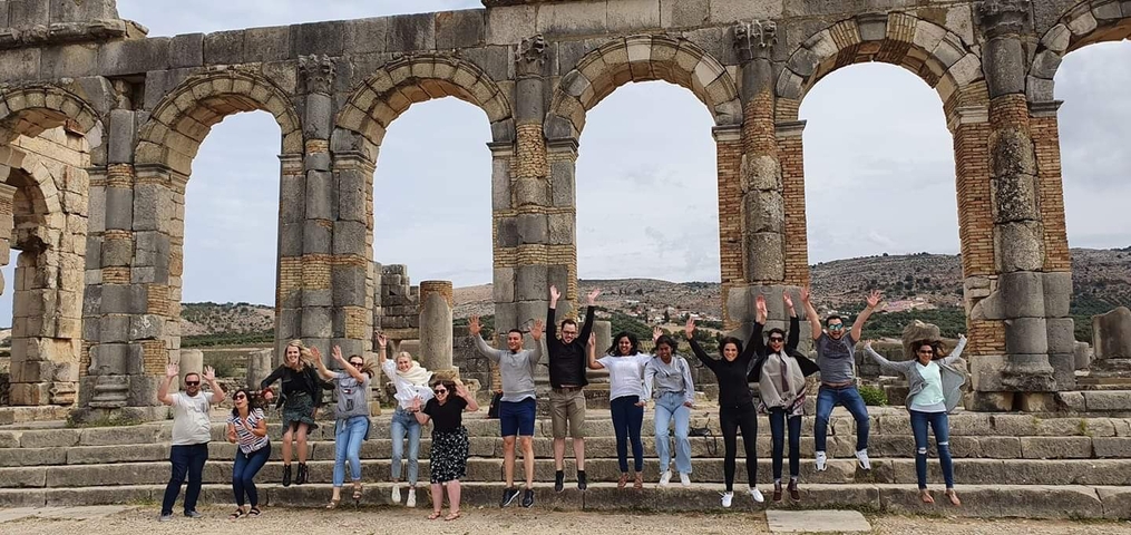       Group jumping in front of ancient ruins.
  