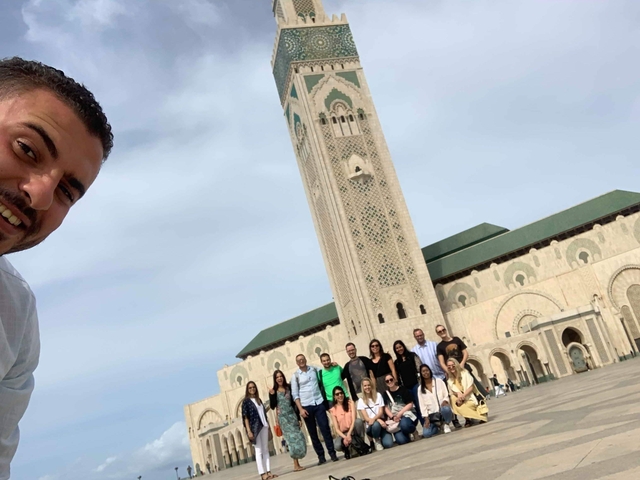       Group posing in front of a large mosque.
  