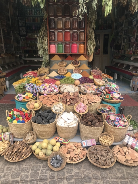       Colorful spices and goods on display in a market.
  