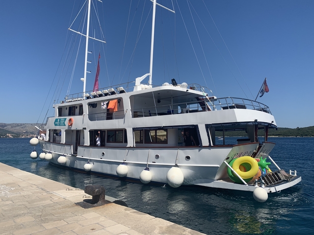 White yacht docked at a pier.