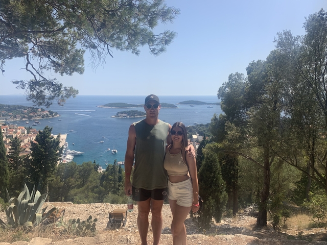 Couple standing with a scenic sea view background.