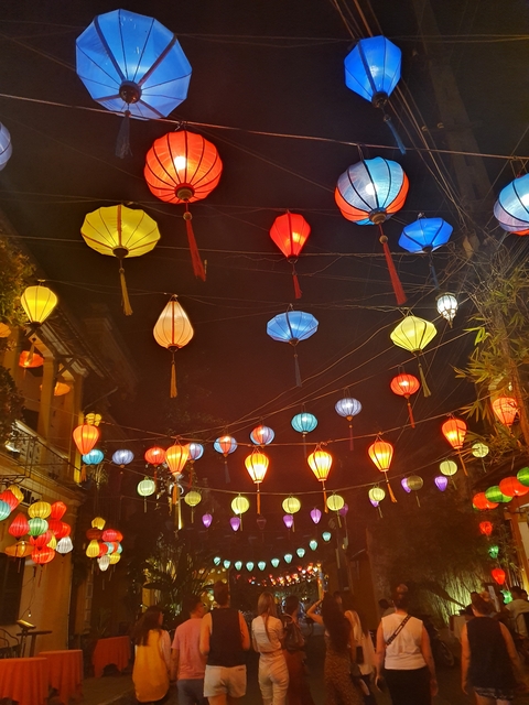 Colorful lanterns lit up at night in a market.