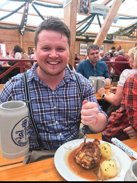A person enjoying a beer at an outdoor festival.