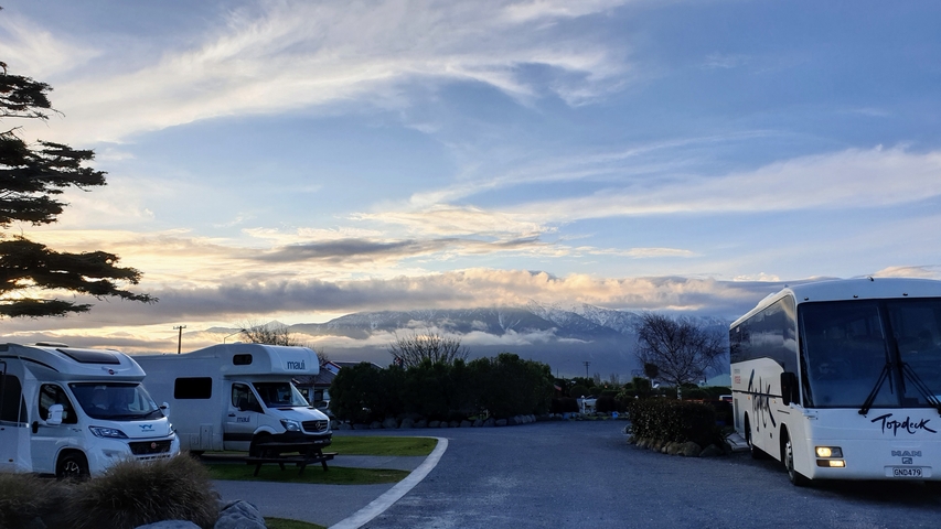 Parked campervans and buses with a mountain view.