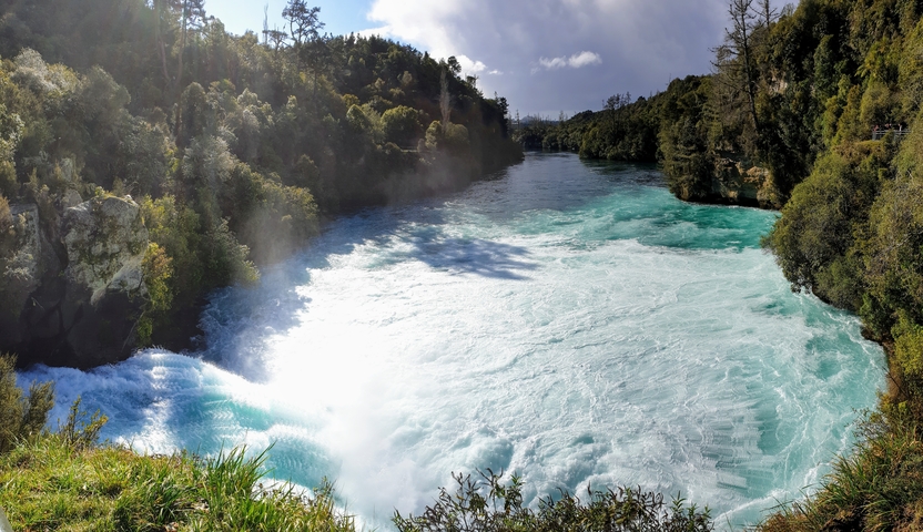 River flowing rapidly down a gorge with vegetation.