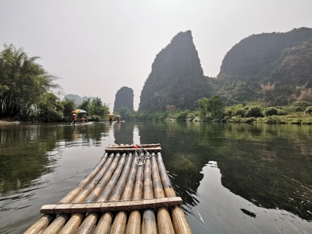 Bamboo raft on a river with karst mountains in the background.