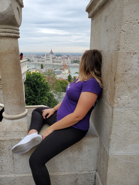A woman relaxing and looking at the Danube and Budapest cityscape.