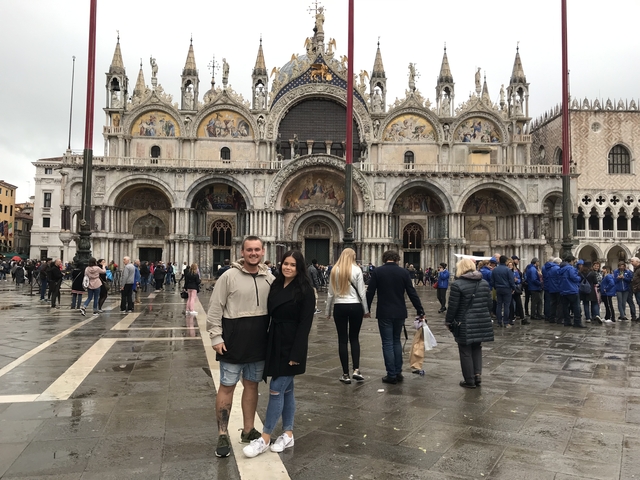 People posing in front of St. Mark's Basilica in Venice.