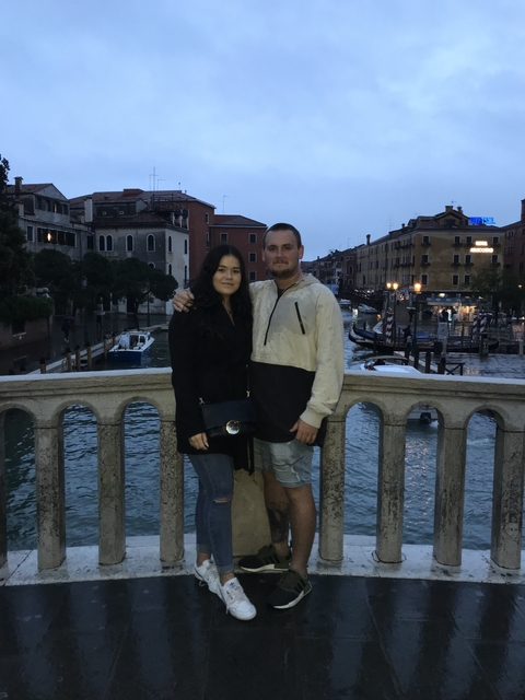Couple on a bridge in Venice during twilight.