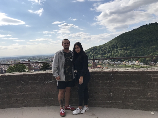 Couple posing with a hilly landscape view in the background.