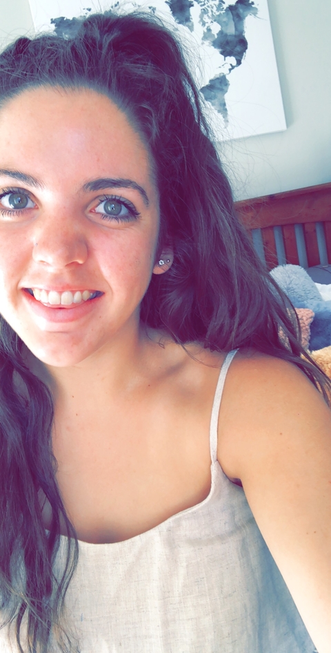 Close-up of a woman smiling indoors.