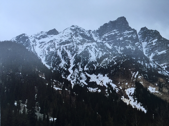 Snow-covered mountains under a grey sky.