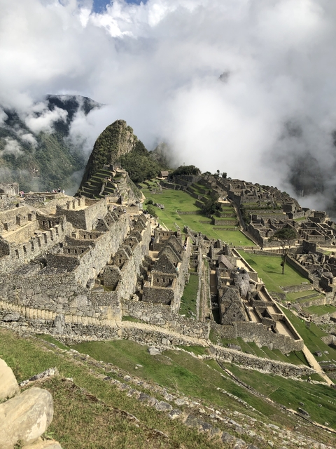 Panoramic view of Machu Picchu with clouds rolling in.