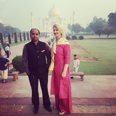       Two people posing with the Taj Mahal in the background.
  