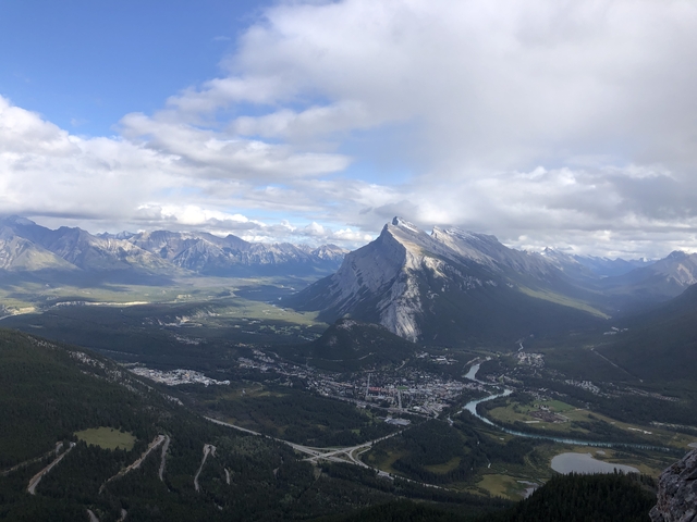 Panoramic view of a valley with mountains and a river.