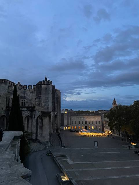       Evening view of a cityscape with illuminated buildings.
  