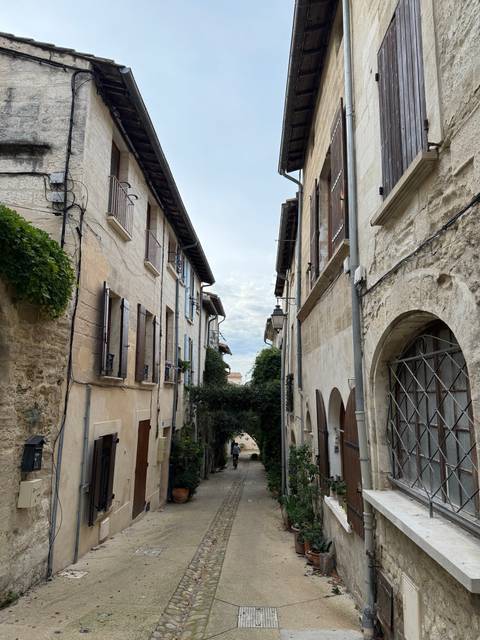       Narrow street between old stone buildings with a cobblestone path.
  