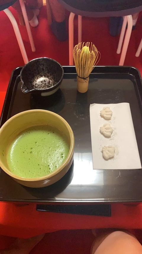 A bowl of matcha with sweets on a tray.