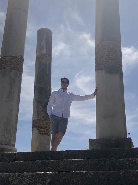       Person standing between large columns.
  