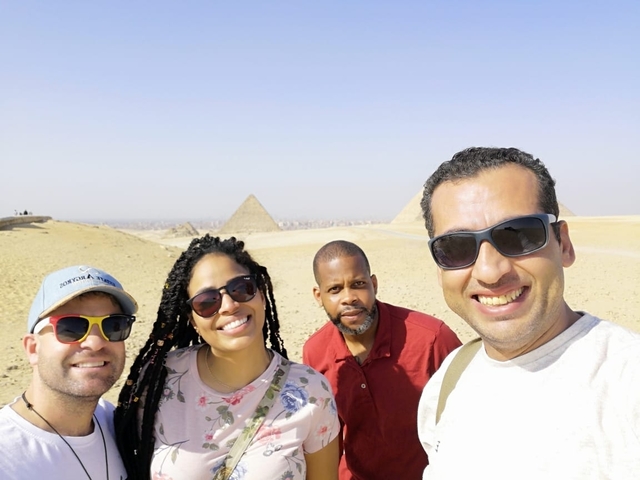       Group of friends with pyramids in the background.
  