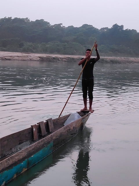       Person paddling on a narrow boat in a river.
  