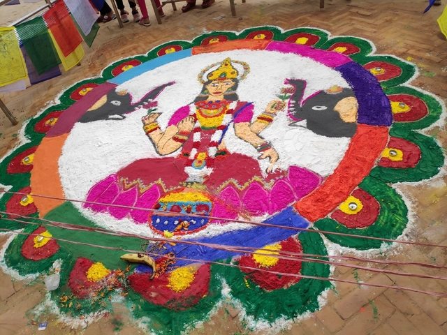       Colorful rangoli with deity and elephants.
  