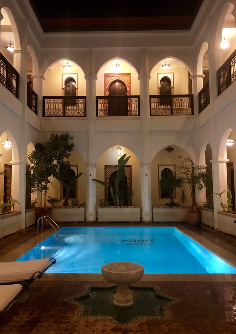       Interior courtyard with pool and arches at nighttime.
  