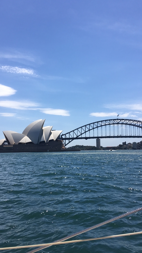 Sydney Opera House and Harbour Bridge with water in the foreground.