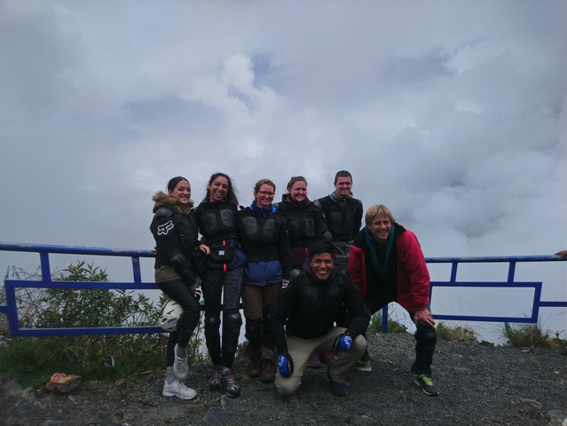 Group of seven people posing on a mountain overlook.