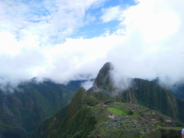 Aerial view of Machu Picchu surrounded by mist and mountains.