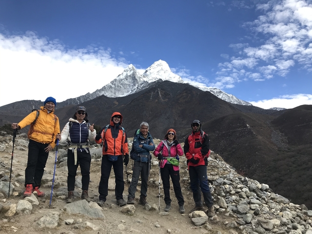 Hikers posing in front of snow-capped mountains.