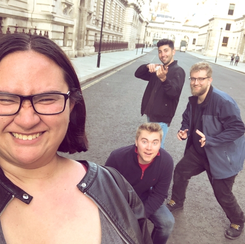 Four people posing on a city street.