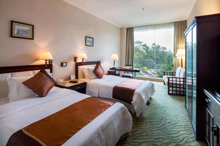 Hotel room with two beds and a large window view.