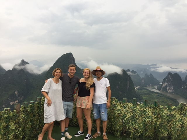 Four people with mountainous landscape in the background.