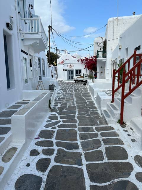       Whitewashed buildings with narrow street in Mykonos.
  