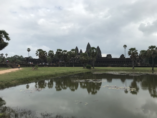 Angkor Wat temple with people by a pond.