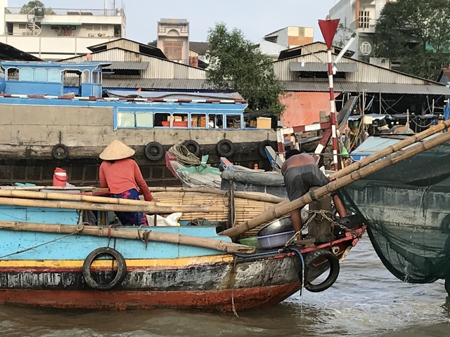 People on a boat in a busy harbor.
