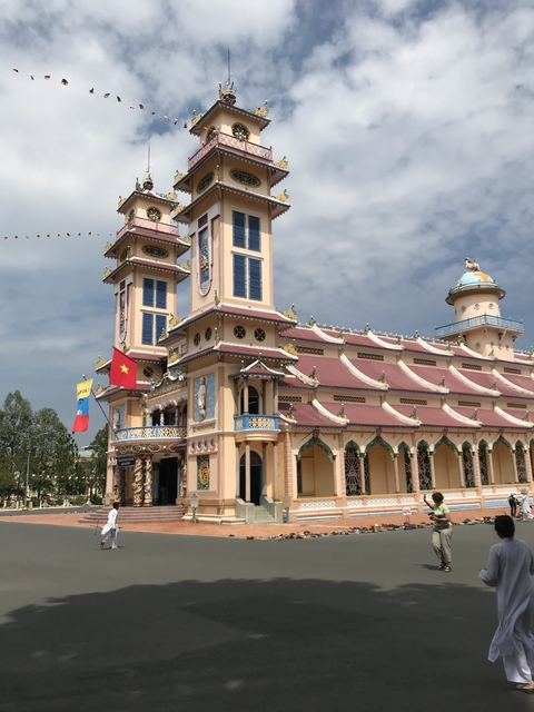       Colorful temple with ornate architecture and flags.
  
