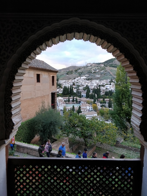       View of a historic cityscape through an ornately designed archway.
  