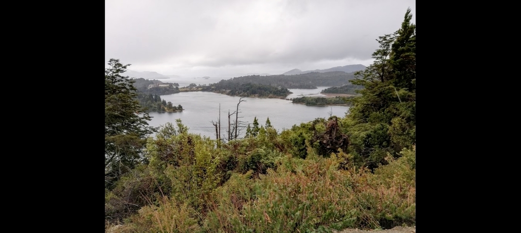       Scenic lake surrounded by trees and hills.
  