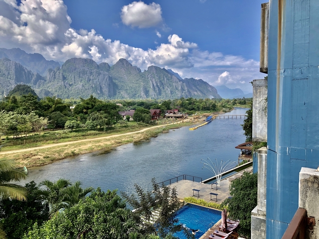       Riverside landscape with mountainous background.
  