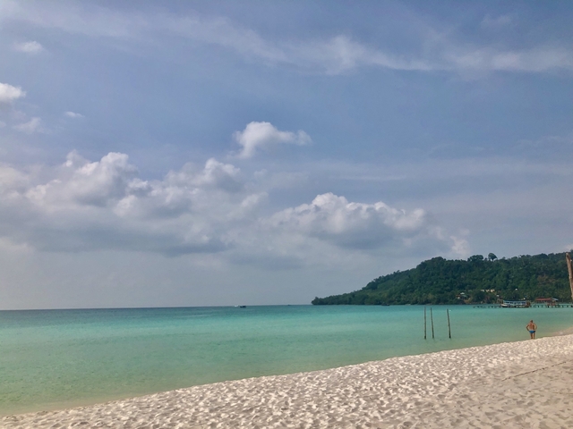       Wide sandy beach with clear turquoise waters.
  
