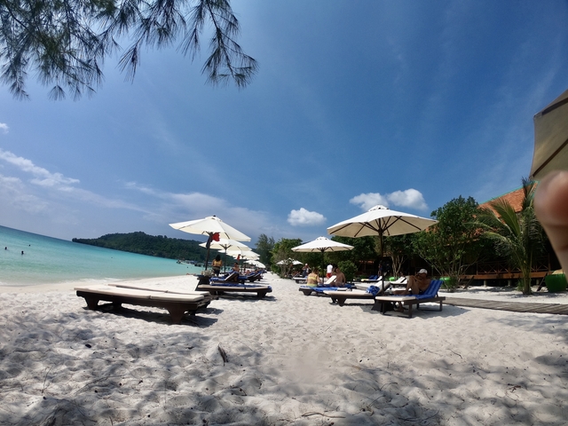       Beach with lounge chairs and turquoise water.
  