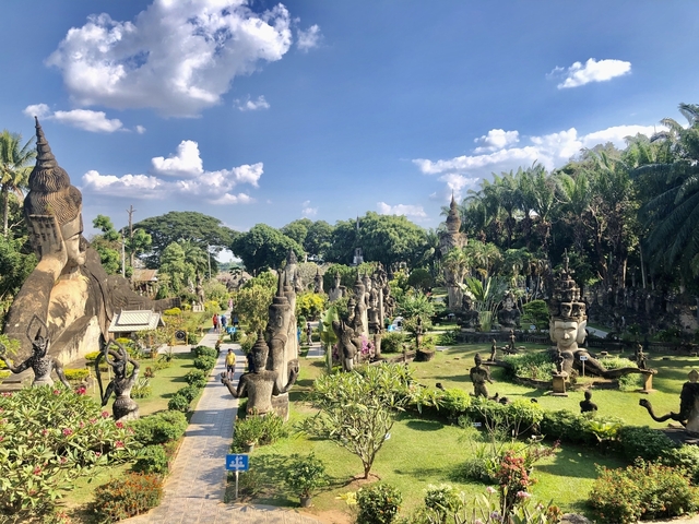       Garden with various sculptures and lush greenery under a clear blue sky.
  